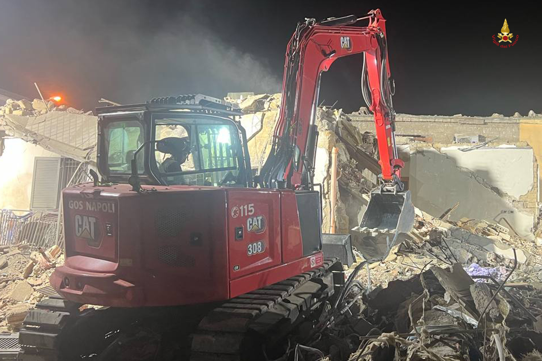 Escavatore rimuove macerie