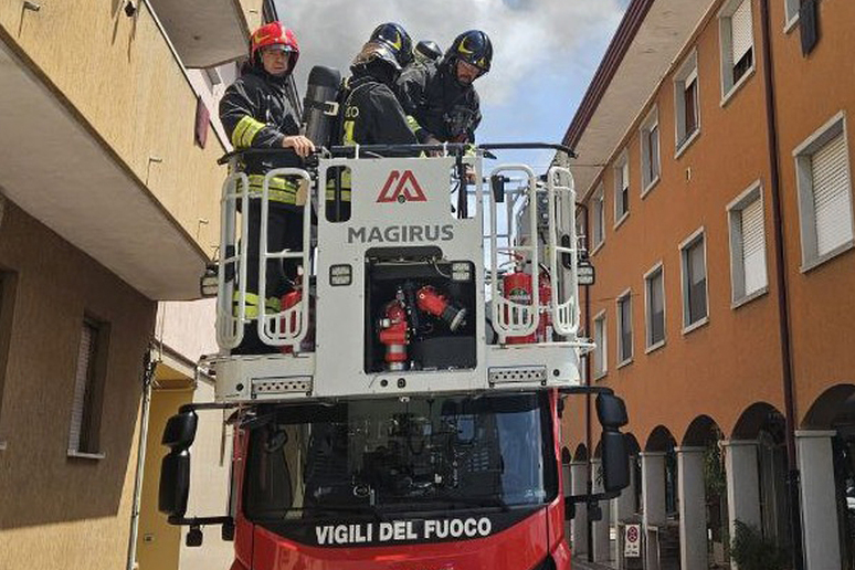 Incendio pannelli fotovoltaici Vigili del fuoco con l'autoscala per raggiungere il tetto di un edificio e spegnere l'incendio di pannelli fotovoltaici