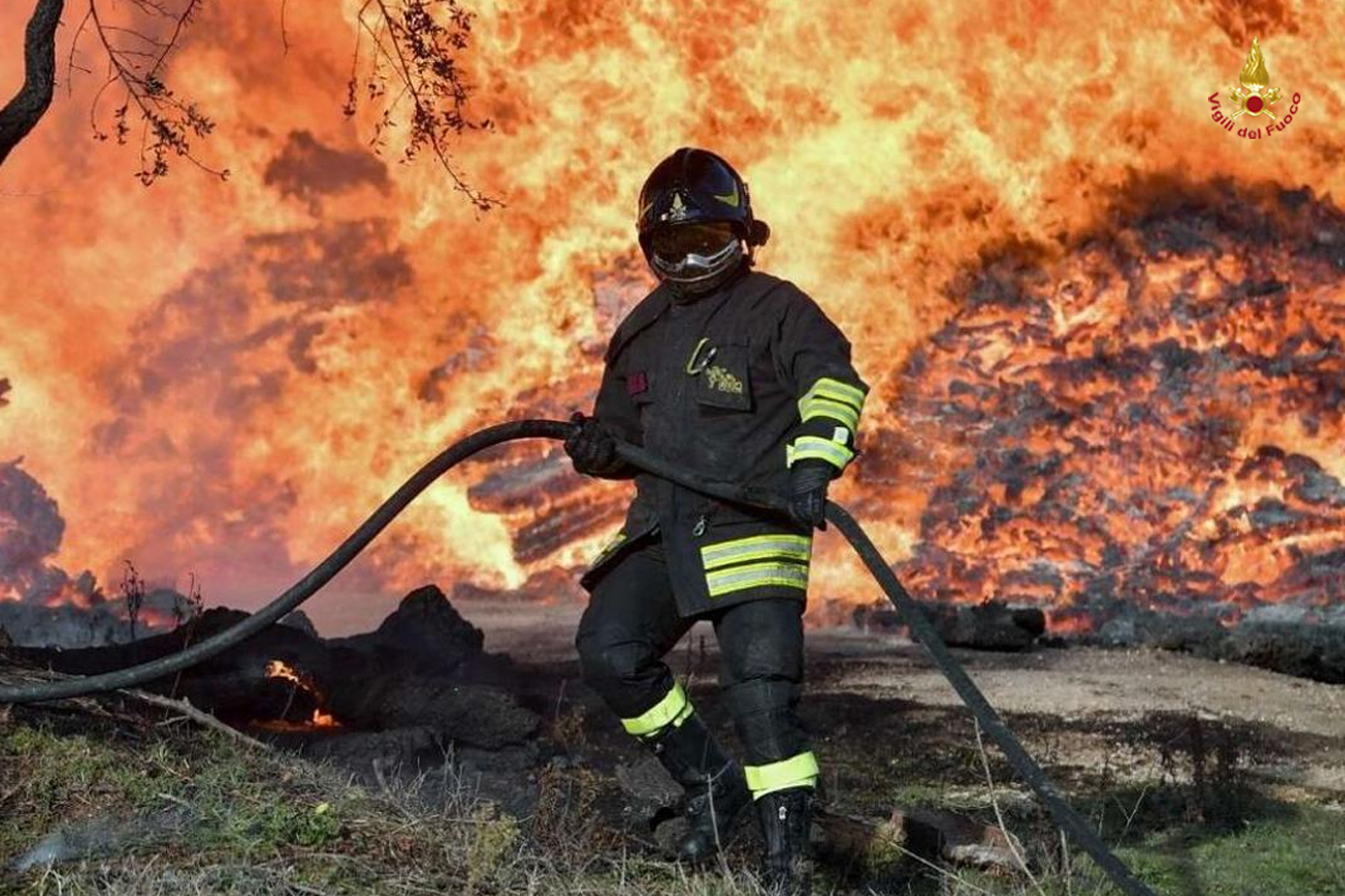 Immagine di repertorio di un vigile del fuoco impegnato nelle operazioni di spegnimento di un vasto incendio boschivo e di vegetazione