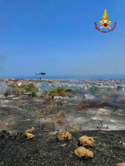 Vigili del fuoco al lavoro per un vasto incendio sterpaglie sull'autostrada A18 e nel comune di Aci Catena