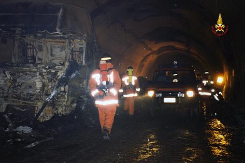 Immagini dell'epoco ache ritraggono i vigili del fuoco impegnati nel traforo del Monte Bianco tra i rottami anneriti dei mezzi