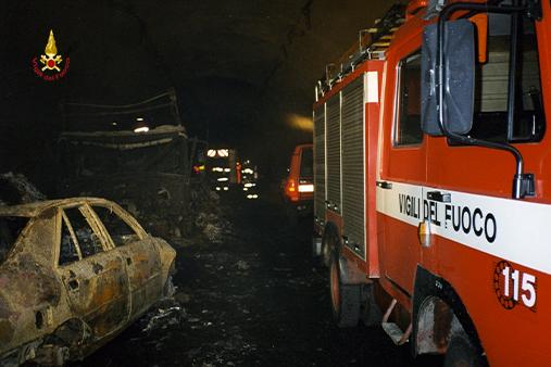 Immagini dell'epoco ache ritraggono i vigili del fuoco impegnati nel traforo del Monte Bianco tra i rottami anneriti dei mezzi