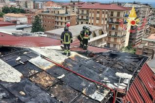 Vigili del fuoco dopo aver finito di spegnere l'incendio sul tetto di una palazzina in via Duca d'Aosta a Lamezia Terme