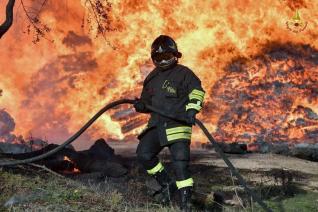 Immagine di repertorio di un vigile del fuoco impegnato nelle operazioni di spegnimento di un vasto incendio boschivo e di vegetazione