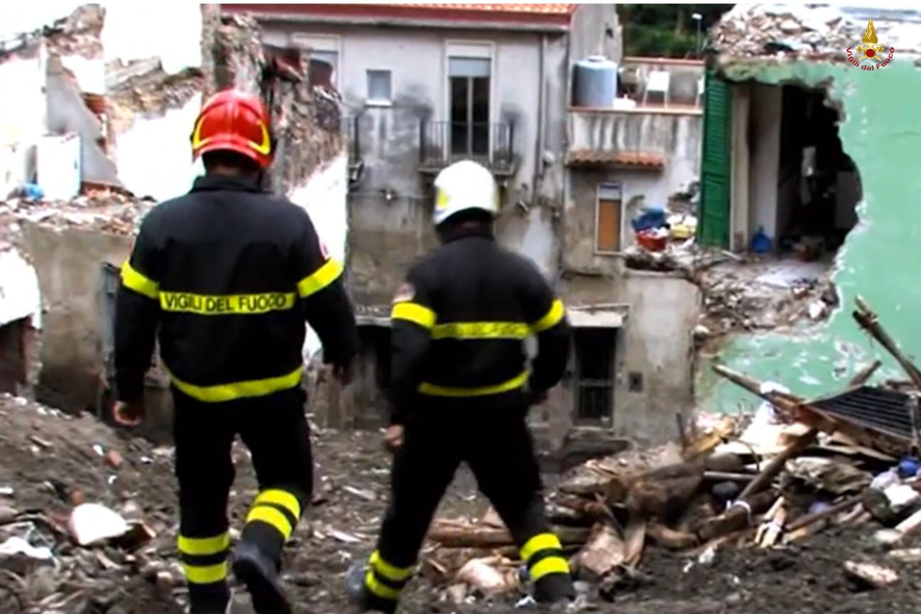 Vigili del fuoco contemplano la devastazione della frana a Giampilieri