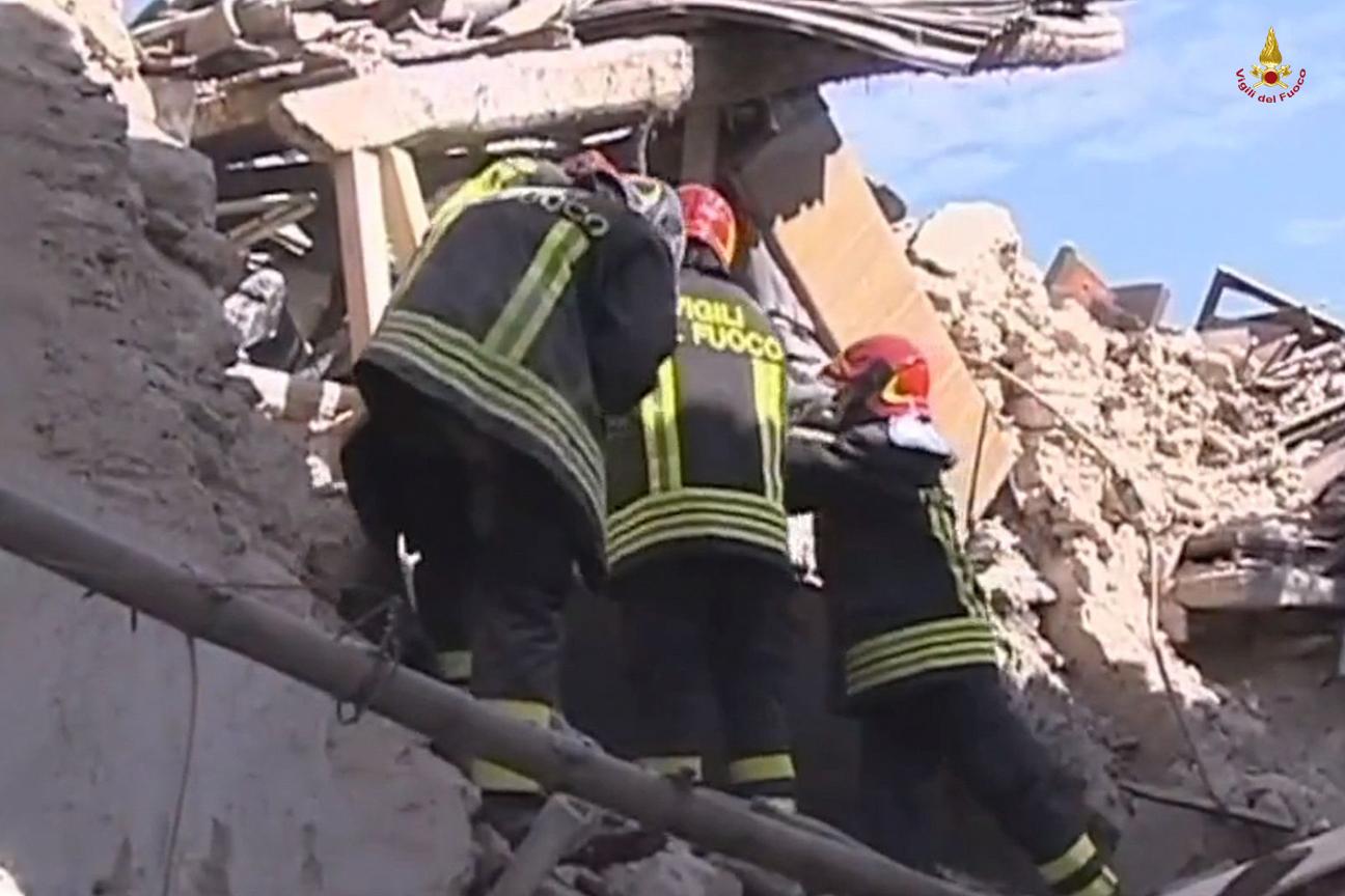 Vigili del fuoco al lavoro tra le macerie dell'Aquila dopo il terremoto del 6 aprile 2009